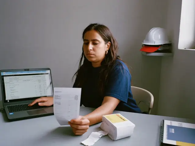 Contadora revisando un ticket frente a su hoja de cálculo